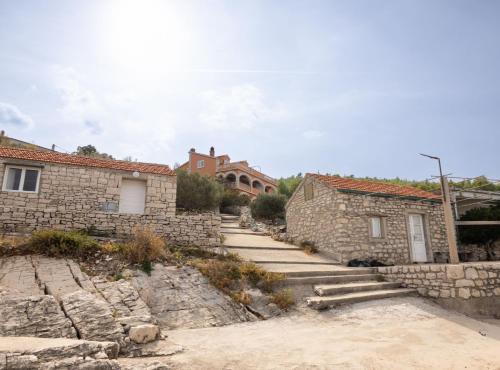 a stone house with a stone wall and stairs at Apartments Sea Line in Prigradica