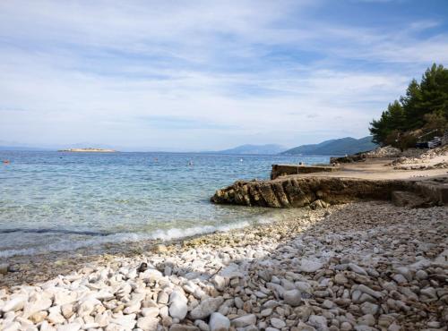 a beach with rocks and the ocean on a cloudy day at Apartments Sea Line in Prigradica
