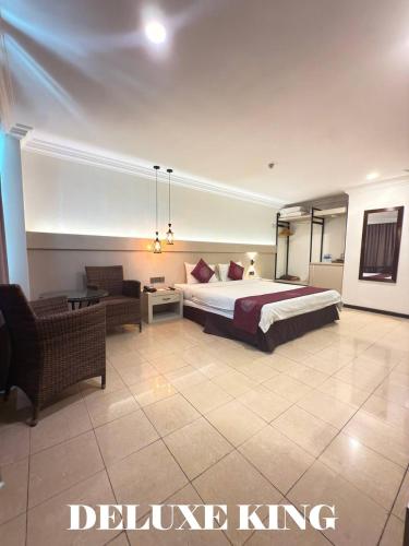 a hotel room with a bed and a living room at Heritage Hotel in Tawau