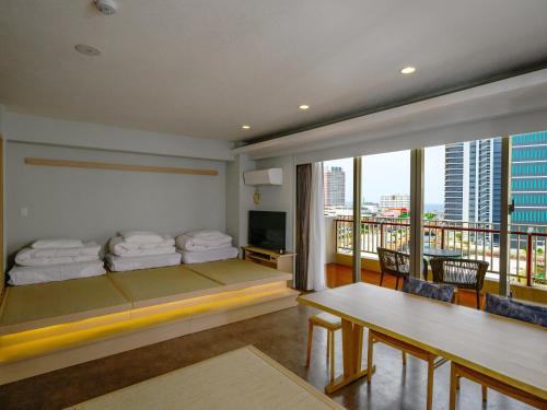 a hotel room with a bed and a balcony at TATAMI NO YADO Chatan Mihama by COLDIO in Chatan