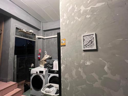 a bathroom with a washer and dryer on a wall at Stay Strays Hostel in Bangkok