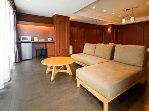 a living room with a couch and a table at TATAMI NO YADO Chatan Mihama by COLDIO in Chatan