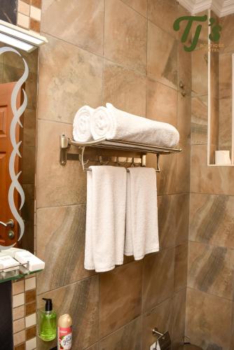 a bathroom with white towels on a towel rack at TJ's Boutique Hotel in Eldoret