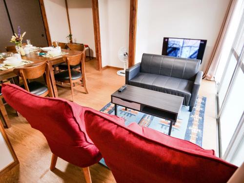a living room with a table and a couch at Family Villa KASAMA in Kasama