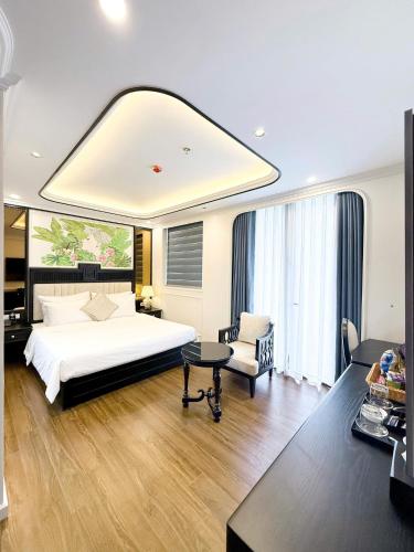 a bedroom with a large white bed and a chair at Royal Hotel Lâm Hạ in Hanoi