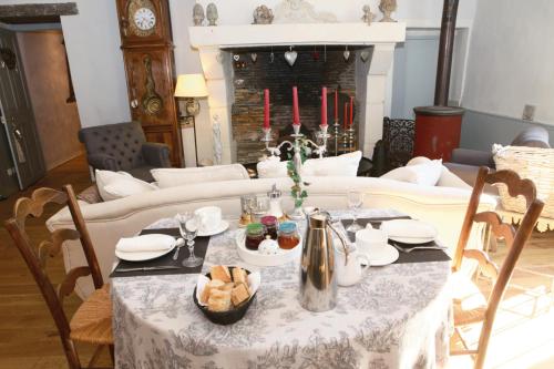 a living room with a table and a fireplace with red candles at La Gentilhommière in Chantepie