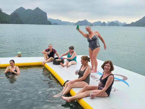 a group of people sitting on a raft in the water at Manh Vuong Buotique Hotel in Cat Ba