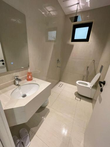 a white bathroom with a sink and a toilet at شقة ياسمين الفندقية in Medina