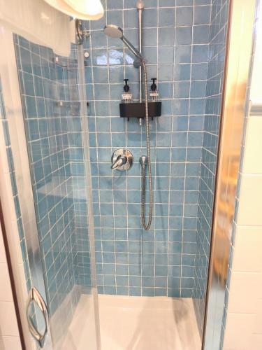 a bathroom with a shower with blue tiles at Il Chicco di Arianna in Torre del Lago Puccini