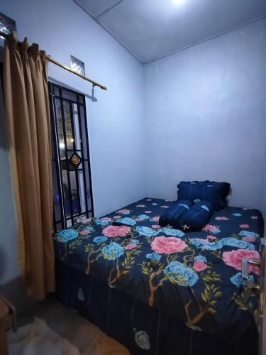 a bedroom with a bed with a floral bedspread at Villa Bukit Asri Berastagi in Berastagi