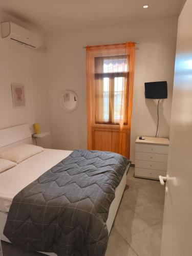 a bedroom with a bed and a window at Il Chicco di Arianna in Torre del Lago Puccini