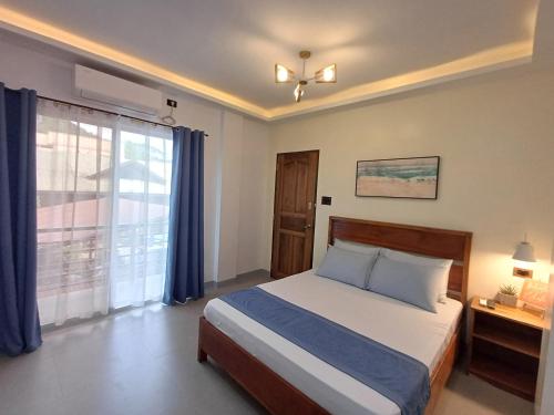 a bedroom with a bed and a large window at Elisha's Guest House in Coron