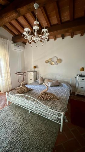 a bedroom with a large bed with a chandelier at Villa Borgo Soale in Reggello