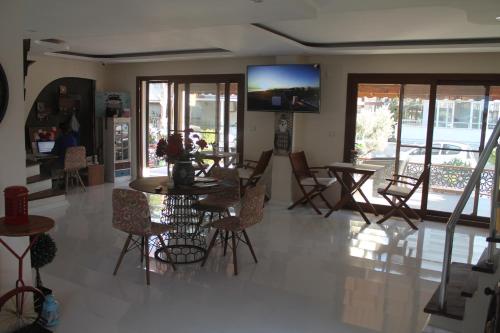 a living room with a table and chairs and a tv at Lila Butik Hotel Dikili in Dikili