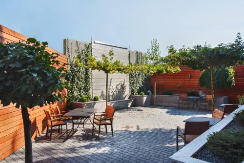 a patio with chairs and tables and a tree at Hotelik B&B Pod Dębami in Radwanice