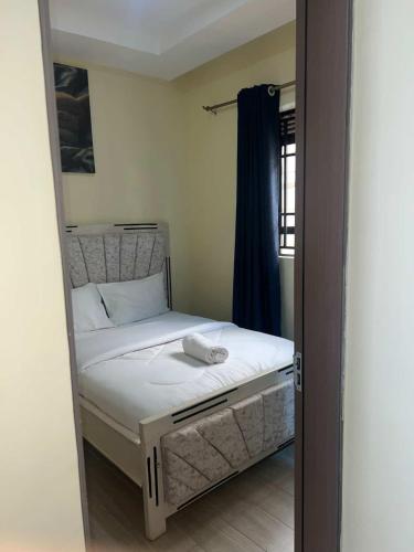 a small bedroom with a bed and a mirror at Rosebank Villas in Luanda