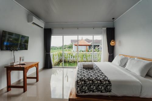 a bedroom with a bed and a large window at Taman Villa Kelating in Krambitan