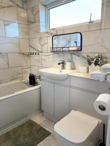 a white bathroom with a sink and a toilet at Cosy one bed Flat in Stevenage in Stevenage