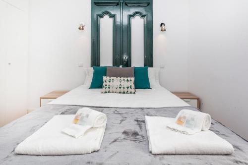 un letto con due asciugamani sopra di Apartment Yellow Bica a Lisbona