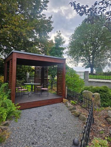 a wooden pavilion with a table and chairs in a garden at Penzion u Vodníka in Třeboň