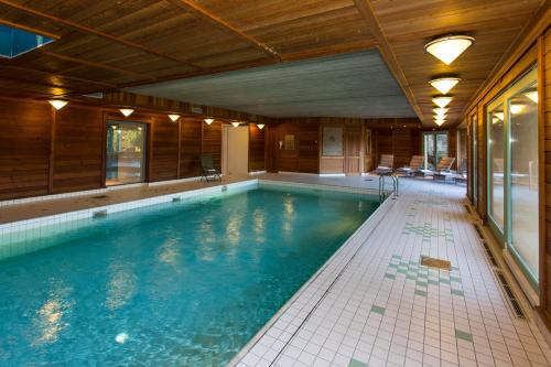 a swimming pool in a house at Le Manoir Au Lac in Gérardmer