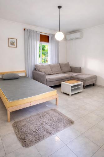 ein Wohnzimmer mit einem Bett und einer Couch in der Unterkunft Stay in Corroios Near Lisbon and 15 Min from the Beach - Casa Acolhedora em Corroios Perto de Lisboa e da Praia in Corroios