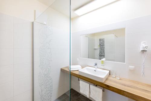 a bathroom with a sink and a mirror at Weinhof Reichmann in Sankt Peter am Ottersbach