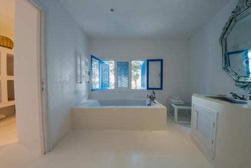 a white bathroom with a tub and a sink at Villa Kahina in Carthage