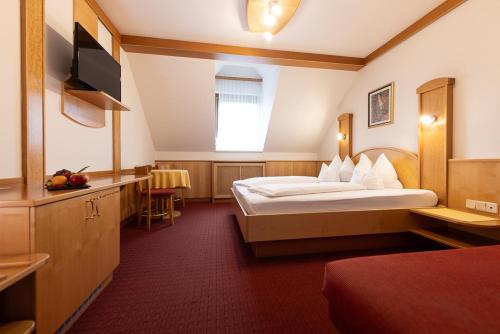a hotel room with a bed and a television at Maria Theresien Hof Loipersdorf in Jennersdorf