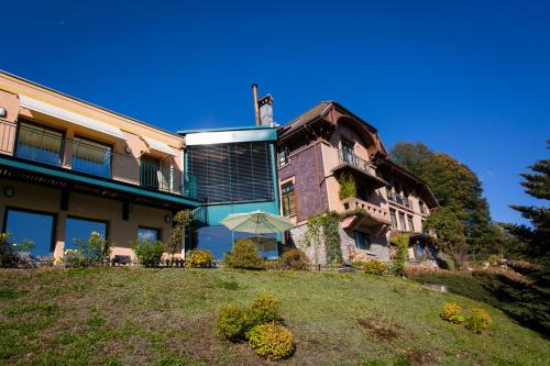 a large building with a lawn in front of it at Le Manoir Au Lac in Gérardmer