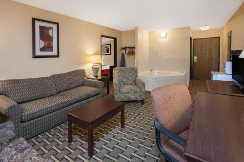 a living room with a couch and a table at Days Inn & Suites by Wyndham Madison Heights MI in Madison Heights