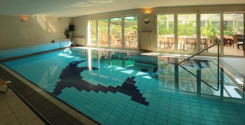 una grande piscina con piastrelle blu in un edificio di Cezar Naturyzm Bielsko-Biała a Bielsko-Biała
