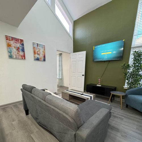 a living room with a couch and a flat screen tv at 2BD DT Dallas l FIFA READY l 5 Min from Love Field in Dallas