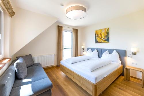 a bedroom with a bed and a couch at Weinhof Reichmann in Sankt Peter am Ottersbach