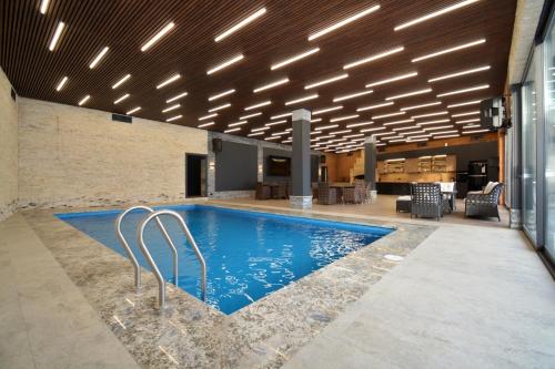 a swimming pool in a building with lights on the ceiling at Homma Aparan with Superpool, 30 min from Yerevan in Aparan