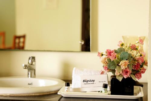 a bathroom counter with a sink and a plate with flowers at BigStay Apart Hotel in Tada
