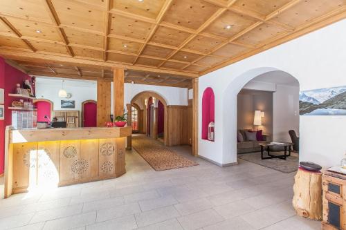 a kitchen and living room with a wooden ceiling at Sleep only in Pontresina