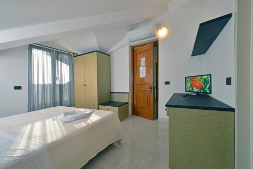 a bedroom with a bed and a television in it at Hotel Garden Bocca di Magra in Bocca di Magra