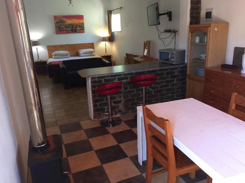 a kitchen with a table and chairs and a room at Pine Valley in Lanseria