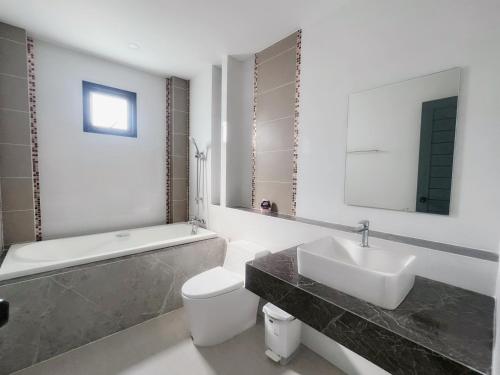 a bathroom with a sink and a toilet and a bath tub at Pool villa Cream Darin in Ban Hua Phrong