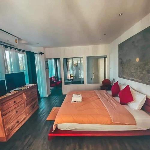 a large bedroom with a large bed with red pillows at Baantidnam in Ban Thung Tho