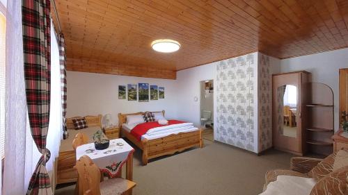 a bedroom with a bed and a table in a room at Apartmán Otília in Ždiar