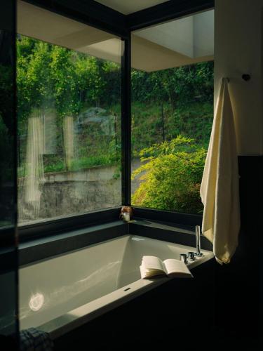 a bathroom with a bath tub with a window at Culinaria living in Tirolo