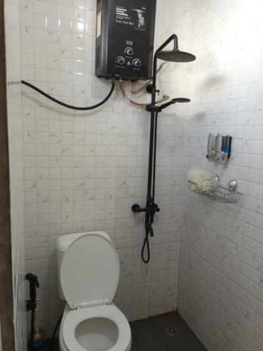 a bathroom with a toilet and a tv on the wall at Sangkuriang 1 - Private Dome in Bandung