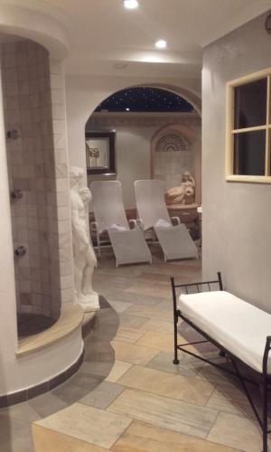 a waiting room with white chairs and a shower at Apart Schmid in See