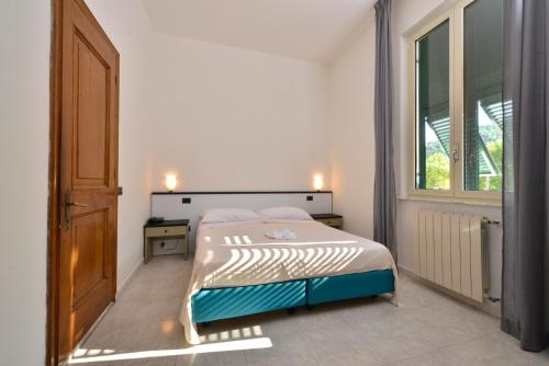 a bedroom with a bed and a large window at Hotel Garden Bocca di Magra in Bocca di Magra