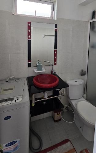 a bathroom with a red sink and a toilet at Green Discovery B&B Tamarind Falls 7 Cascades in Henrietta