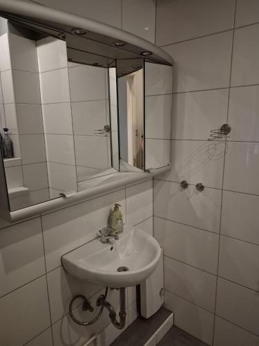 a white bathroom with a sink and a mirror at Flensburg Strandnah in Flensburg