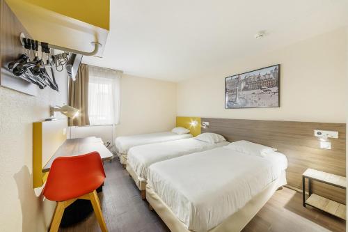 a hotel room with two beds and a red chair at Comfort Hotel Lille Lomme in Lomme