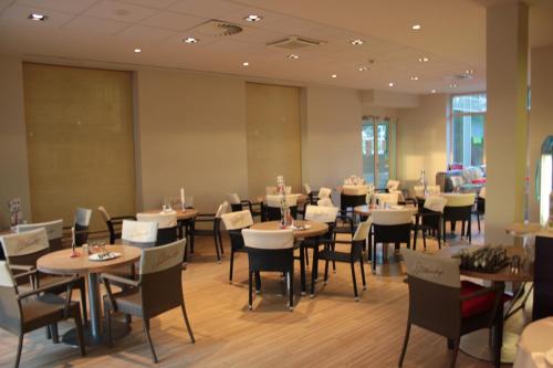 a dining room with tables and chairs in it at Wellness Apartments in Velence in Velence